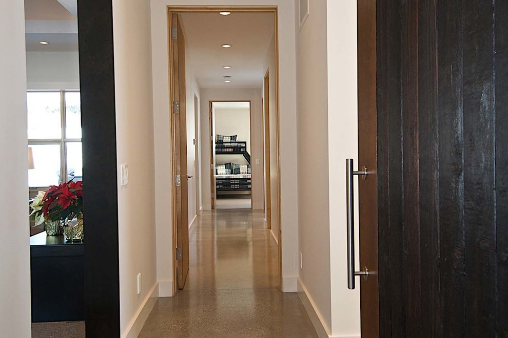 Example of a mid-sized mountain style brown floor hallway design with white walls