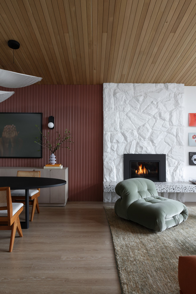 Retro Wohnzimmer mit bunten Wänden, Laminat, Kamin, Kaminumrandung aus Stein und Holzwänden in Vancouver