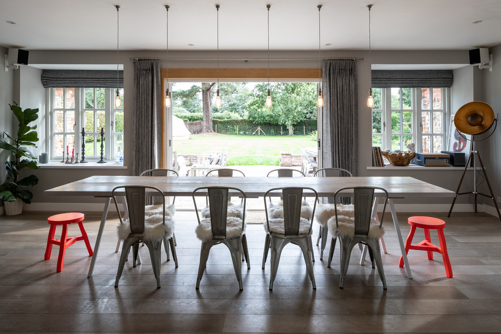 Photo of a beach style dining room in Sussex with grey walls, medium hardwood floors and brown floor.