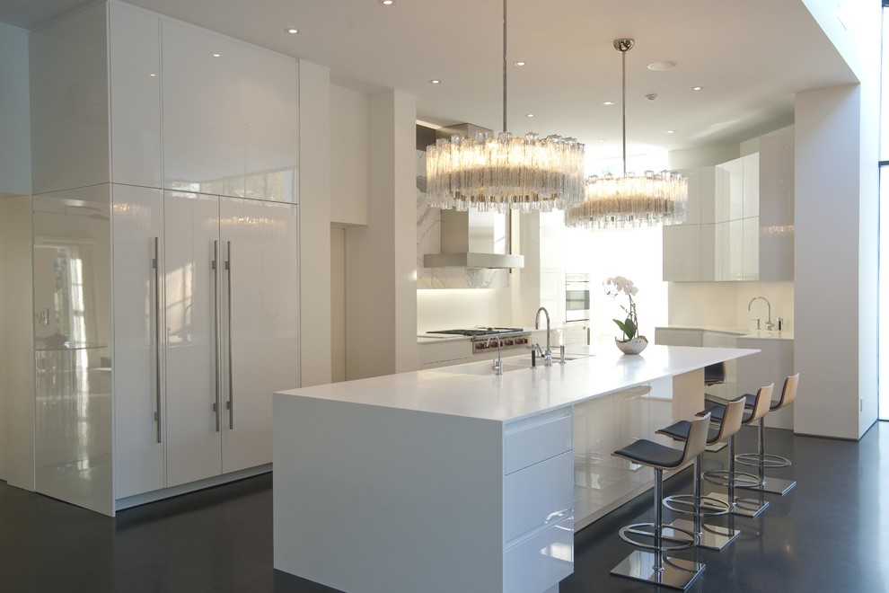 Large contemporary galley eat-in kitchen in Dallas with an undermount sink, flat-panel cabinets, white cabinets, solid surface benchtops, white splashback, porcelain splashback, stainless steel appliances, concrete floors and with island.
