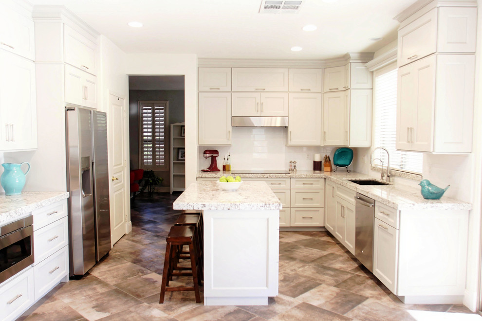 Mid-sized transitional u-shaped porcelain tile and gray floor eat-in kitchen photo in Phoenix with a double-bowl sink, shaker cabinets, gray cabinets, granite countertops, white backsplash, subway tile backsplash, stainless steel appliances, an island and white countertops