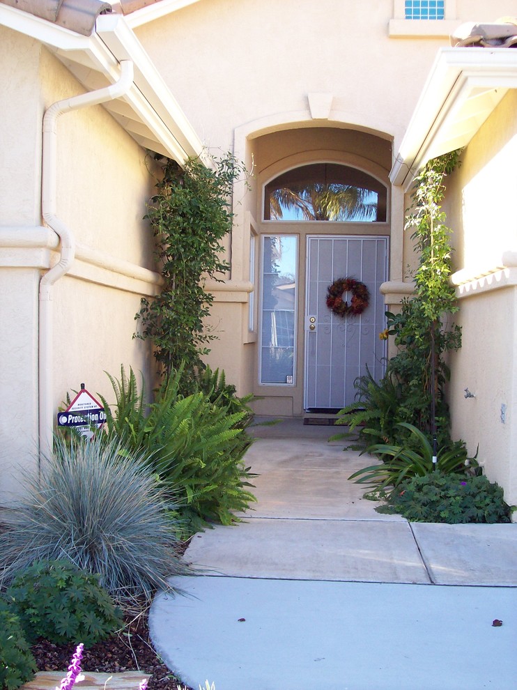 This is an example of a mid-sized traditional entryway in San Diego with beige walls, concrete floors, a single front door and a white front door.