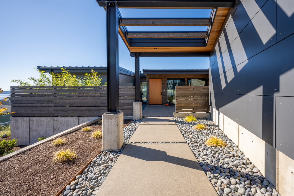 Idee per un giardino xeriscape moderno esposto in pieno sole di medie dimensioni in primavera con pavimentazioni in cemento e recinzione in legno