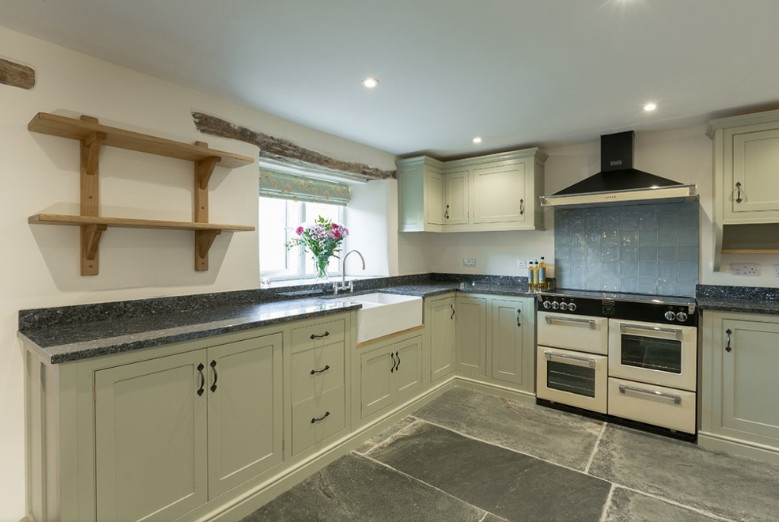 Large country u-shaped separate kitchen in Cornwall with a farmhouse sink, shaker cabinets, grey cabinets, granite benchtops, blue splashback, ceramic splashback, panelled appliances, slate floors, no island, grey floor and grey benchtop.