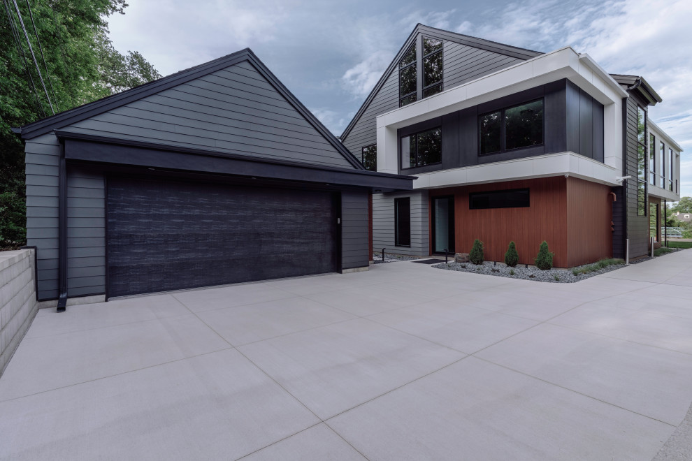 Inspiration pour une façade de maison grise minimaliste en bardage à clin de taille moyenne et à deux étages et plus avec un revêtement mixte, un toit à deux pans, un toit en shingle et un toit noir.