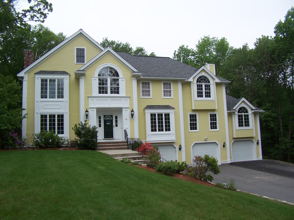 This is an example of a large traditional three-storey yellow house exterior in Boston with wood siding, a gable roof and a shingle roof.
