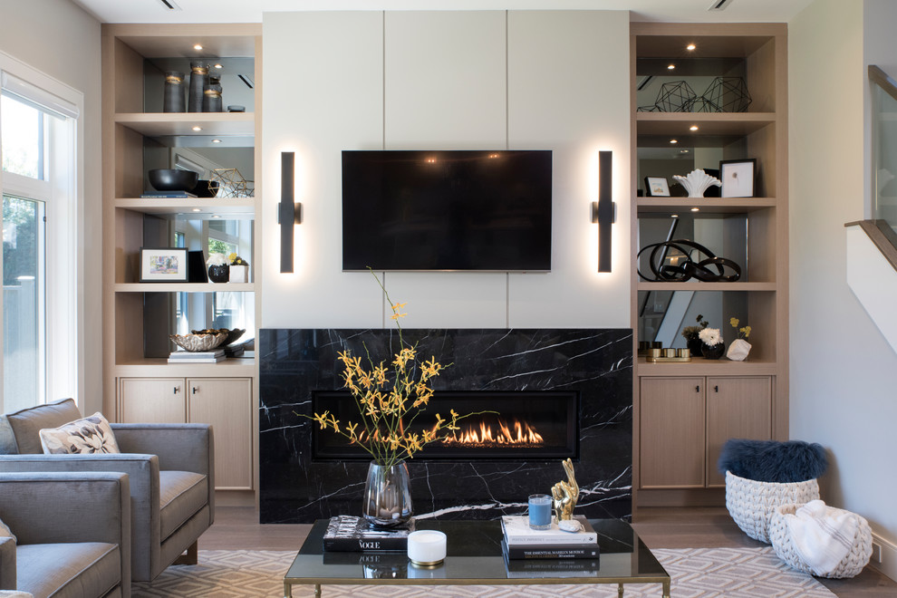 Photo of a mid-sized transitional formal open concept living room in Vancouver with grey walls, medium hardwood floors, a standard fireplace, a stone fireplace surround, a wall-mounted tv and brown floor.