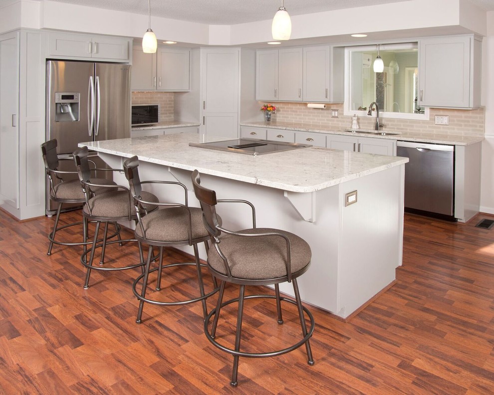 Mid-sized transitional u-shaped medium tone wood floor and brown floor eat-in kitchen photo with a double-bowl sink, gray cabinets, granite countertops, gray backsplash, subway tile backsplash, stainless steel appliances, an island and shaker cabinets