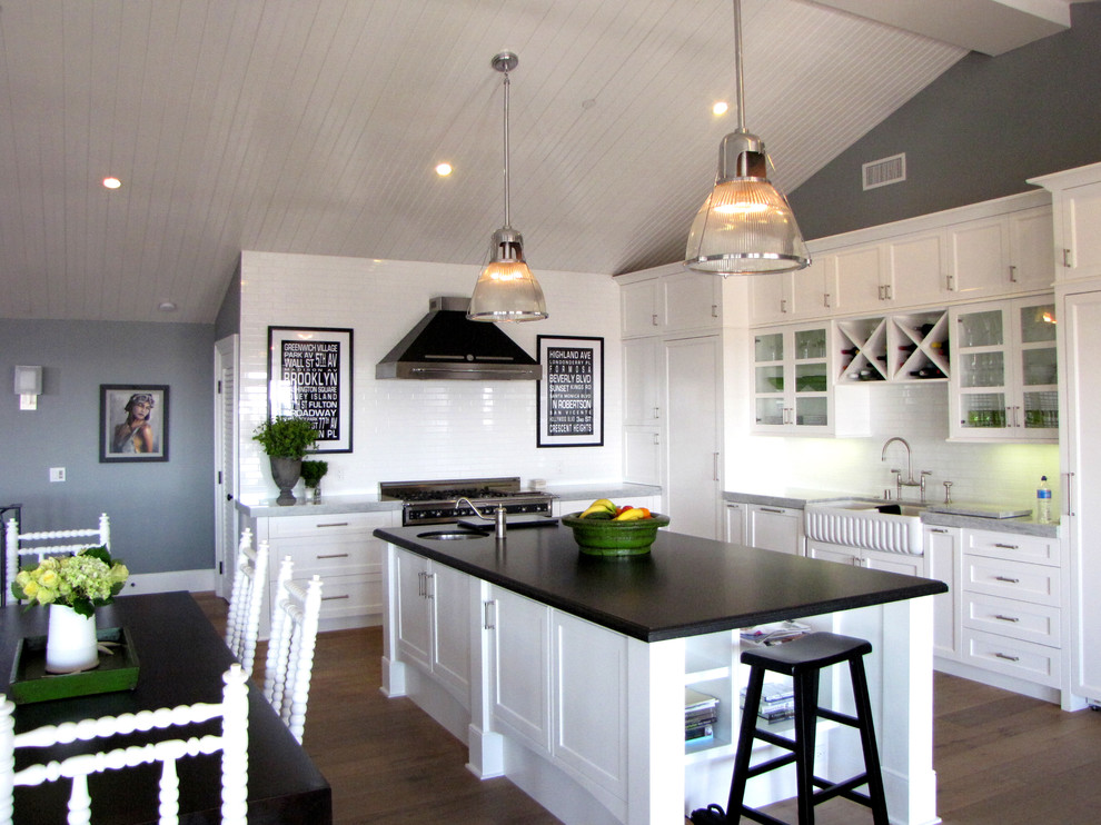 Design ideas for a beach style l-shaped eat-in kitchen in Orange County with a farmhouse sink, shaker cabinets, white cabinets, granite benchtops, white splashback and stainless steel appliances.
