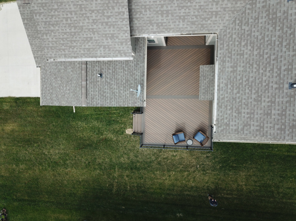 Example of a large courtyard ground level metal railing deck design with no cover