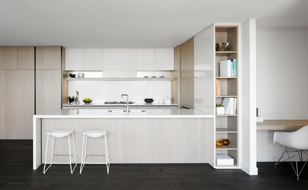 Mid-sized modern galley open plan kitchen in Melbourne with light wood cabinets, quartz benchtops, white splashback, stone slab splashback and with island.