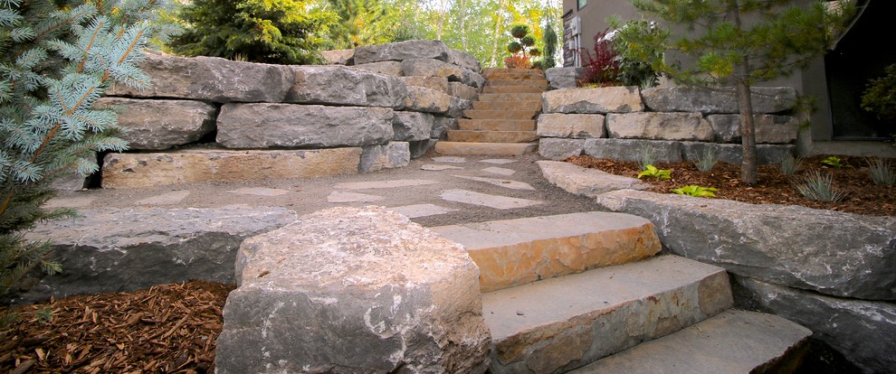 This is an example of a large rustic partial sun side yard retaining wall landscape in Edmonton for summer.