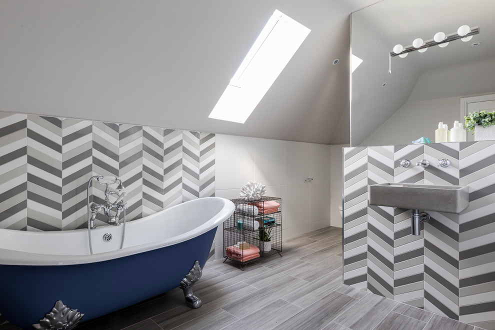 Mid-sized transitional master bathroom in Cheshire with an open shower, a wall-mount toilet, a wall-mount sink, an open shower, a claw-foot tub, white tile, grey walls, light hardwood floors and grey floor.