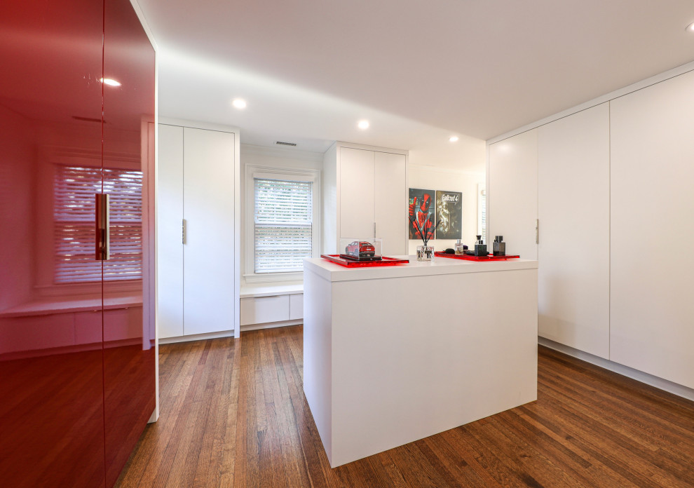Источник вдохновения для домашнего уюта: большая гардеробная комната унисекс в современном стиле с плоскими фасадами, красными фасадами и паркетным полом среднего тона