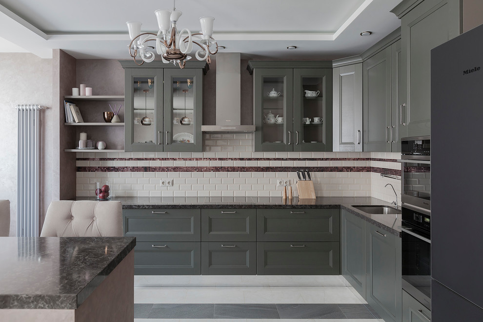 Design ideas for a mid-sized transitional l-shaped open plan kitchen in Moscow with an undermount sink, recessed-panel cabinets, green cabinets, quartz benchtops, beige splashback, subway tile splashback, black appliances, porcelain floors, grey benchtop and grey floor.