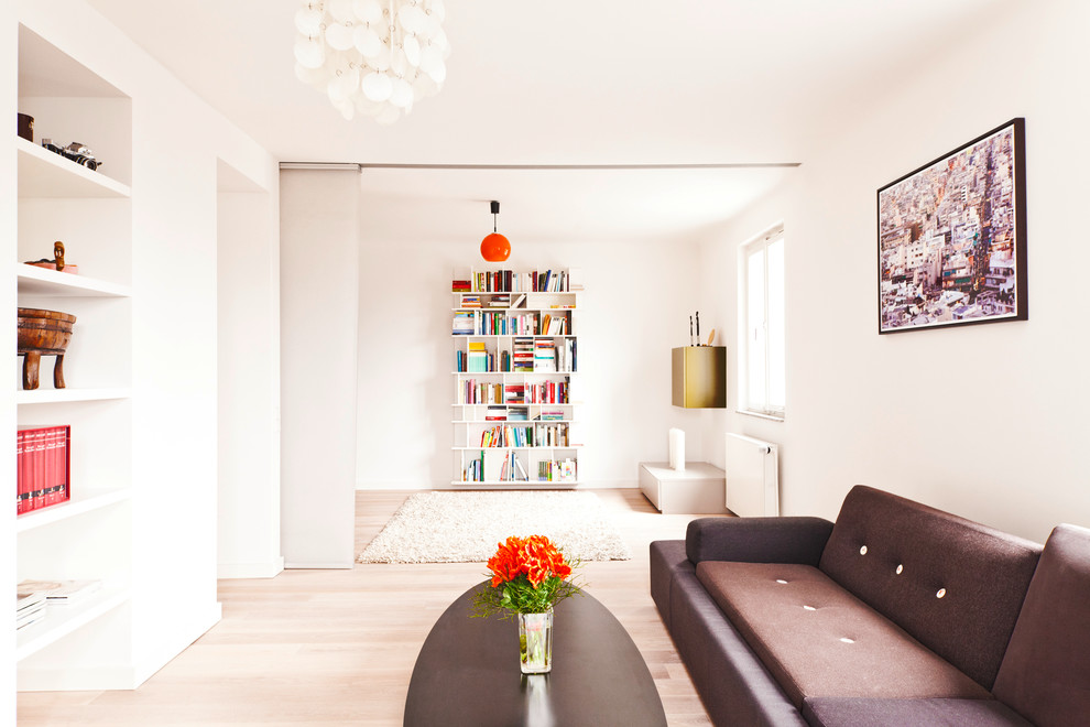 Design ideas for a scandinavian open concept living room in Stuttgart with white walls and light hardwood floors.