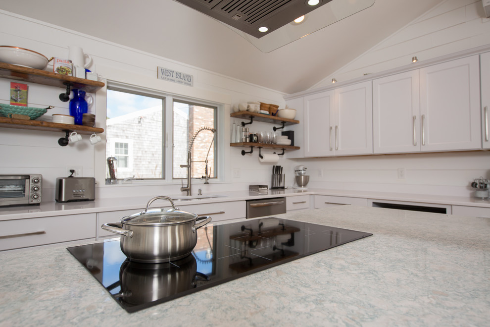 This is an example of a mid-sized beach style l-shaped eat-in kitchen in Providence with an undermount sink, shaker cabinets, white cabinets, quartz benchtops, white splashback, timber splashback, stainless steel appliances, light hardwood floors, with island and yellow floor.