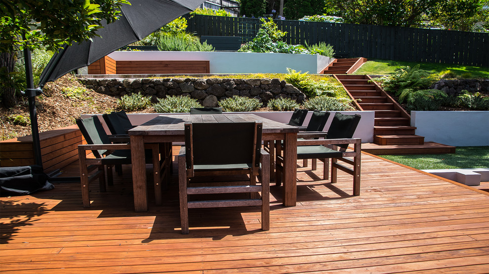 Inspiration for a mid-sized traditional backyard formal garden in Auckland with decking.