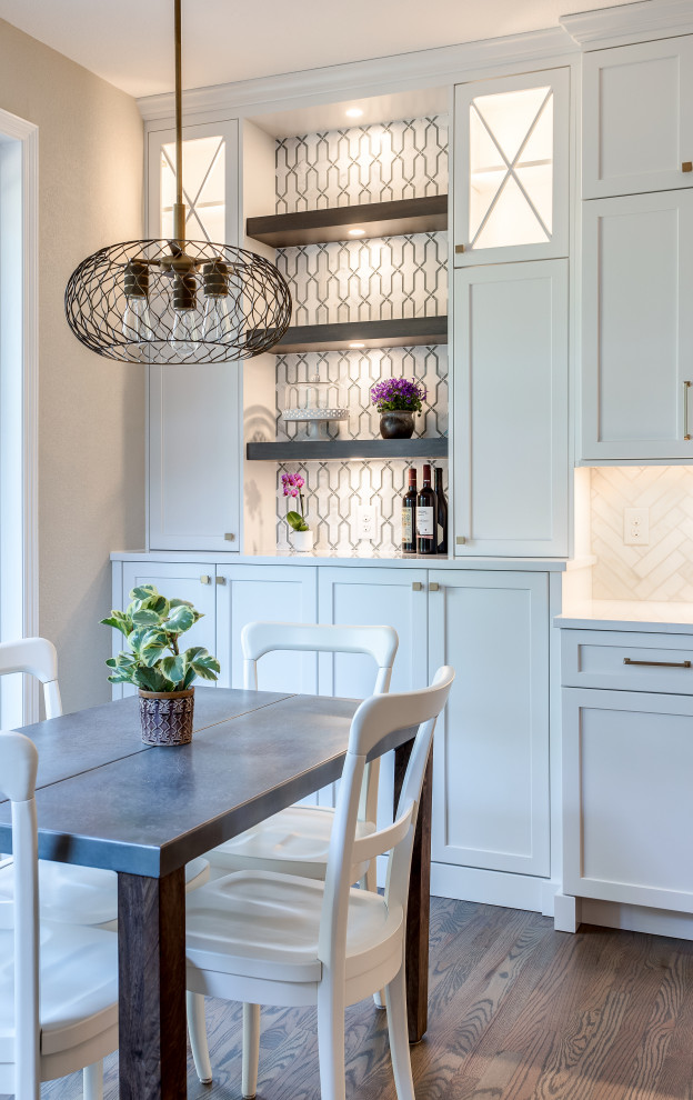 Large transitional galley medium tone wood floor and brown floor open concept kitchen photo in Denver with an undermount sink, shaker cabinets, white cabinets, quartz countertops, beige backsplash, marble backsplash, stainless steel appliances, an island and white countertops