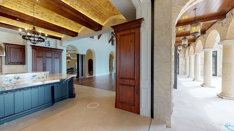 Eat-in kitchen - huge rustic travertine floor and beige floor eat-in kitchen idea in Miami with an undermount sink, beaded inset cabinets, dark wood cabinets, granite countertops, terra-cotta backsplash, paneled appliances, an island and multicolored countertops