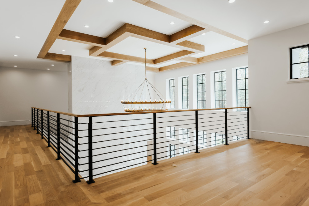 Example of a mid-sized transitional light wood floor hallway design with white walls