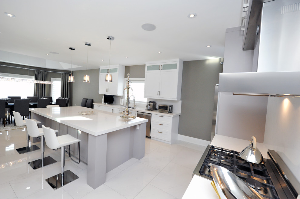 Inspiration for a mid-sized transitional l-shaped porcelain tile kitchen pantry remodel in Toronto with a double-bowl sink, shaker cabinets, gray cabinets, quartz countertops, white backsplash, stone slab backsplash, stainless steel appliances and an island