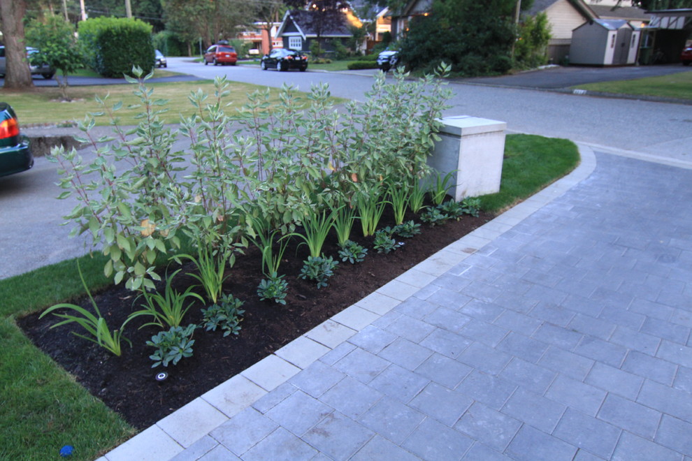 Inspiration for a mid-sized contemporary front yard full sun driveway in Vancouver with concrete pavers.