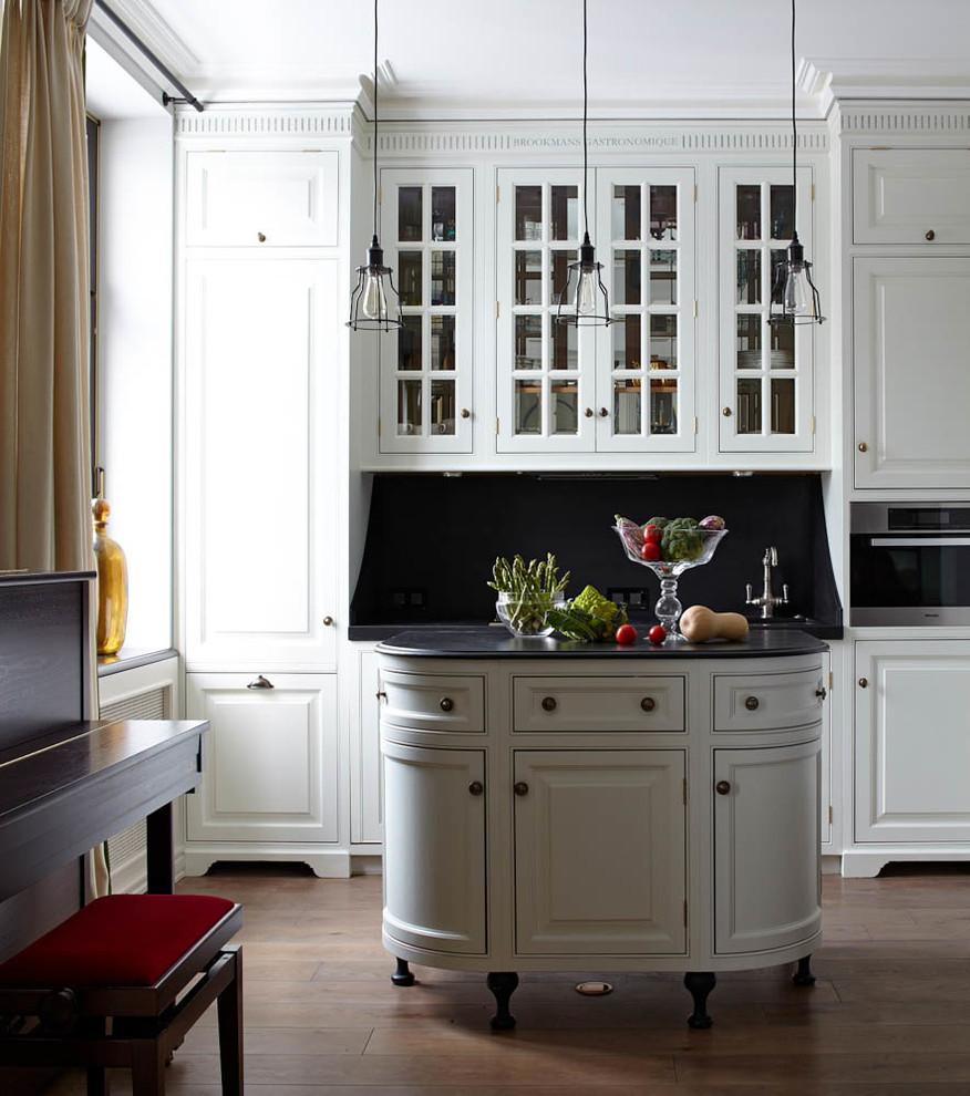 Design ideas for a traditional kitchen in Moscow with white cabinets, black splashback, stainless steel appliances, with island, raised-panel cabinets and medium hardwood floors.