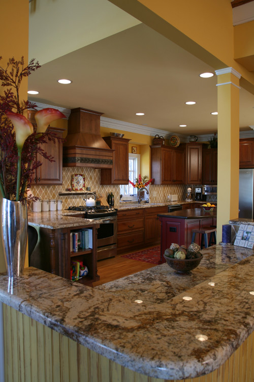 Open concept kitchen - large transitional u-shaped medium tone wood floor open concept kitchen idea in Charlotte with an undermount sink, raised-panel cabinets, dark wood cabinets, granite countertops, ceramic backsplash, stainless steel appliances and an island