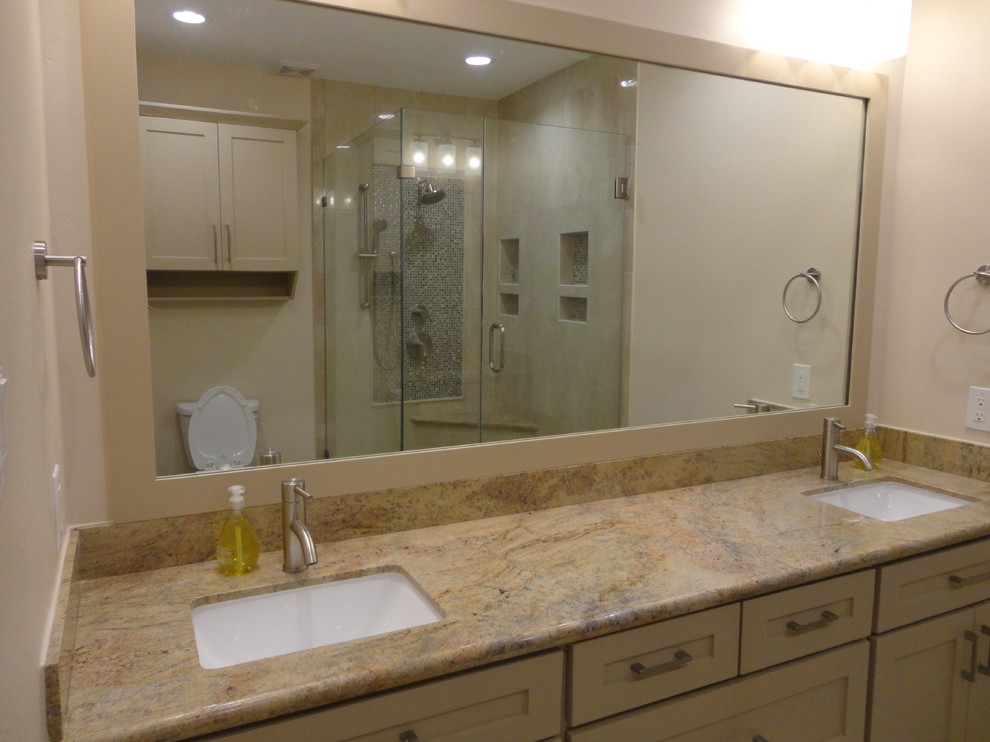 This is an example of a mid-sized contemporary master bathroom in Houston with shaker cabinets, brown cabinets, a corner shower, a two-piece toilet, beige tile, stone tile, brown walls, travertine floors, an undermount sink and granite benchtops.