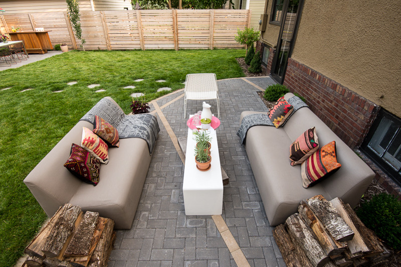 Photo of a mid-sized modern backyard patio in Minneapolis with a fire feature, brick pavers and no cover.