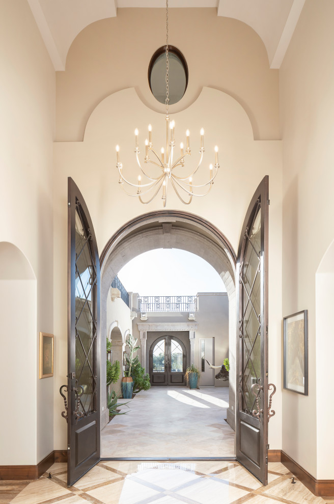 Photo of a large mediterranean foyer in Phoenix with a double front door and vaulted.