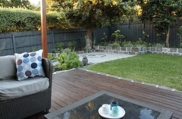 Photo of a mid-sized contemporary backyard partial sun garden in Melbourne with decking.