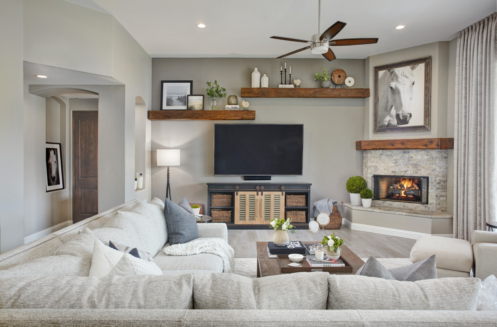 Living room - large transitional open concept porcelain tile and gray floor living room idea in Phoenix with gray walls, a corner fireplace, a stone fireplace and a wall-mounted tv