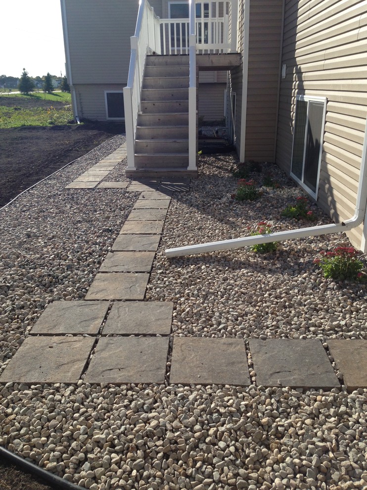Inspiration for a mid-sized transitional side yard partial sun driveway for summer in Other with gravel.