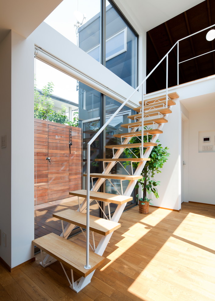 Design ideas for a modern wood straight staircase in Yokohama with open risers and metal railing.