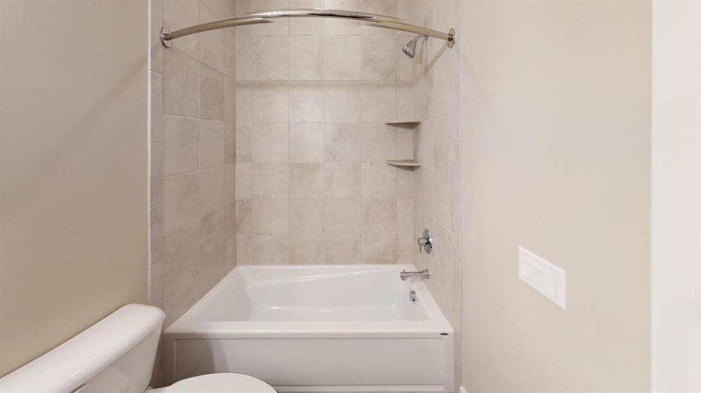 This is an example of a transitional bathroom in Cincinnati with a shower/bathtub combo, beige walls and a shower curtain.