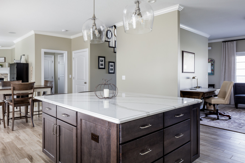 Mid-sized transitional l-shaped ceramic tile and gray floor eat-in kitchen photo with an undermount sink, shaker cabinets, white cabinets, quartz countertops, white backsplash, marble backsplash, stainless steel appliances, an island and gray countertops