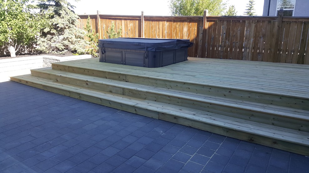 Inspiration for a large backyard full sun garden in Calgary with concrete pavers.