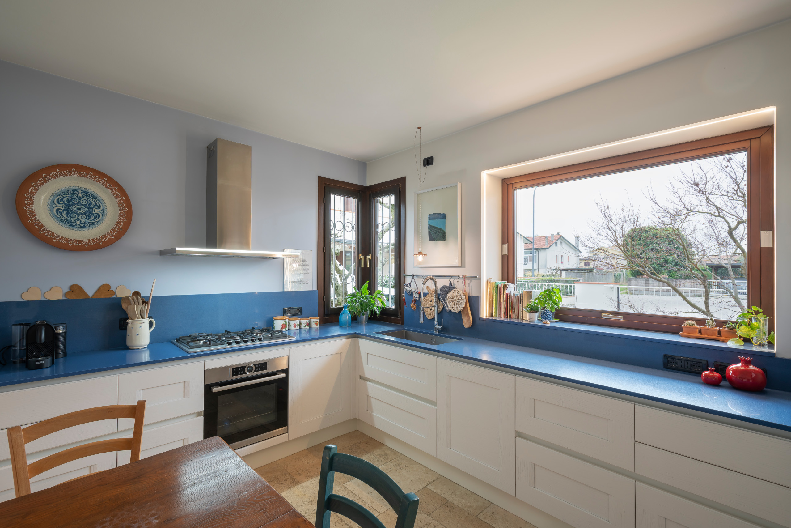 Example of a mid-sized classic l-shaped marble floor and beige floor enclosed kitchen design in Other with a drop-in sink, recessed-panel cabinets, white cabinets, marble countertops, blue backsplash,