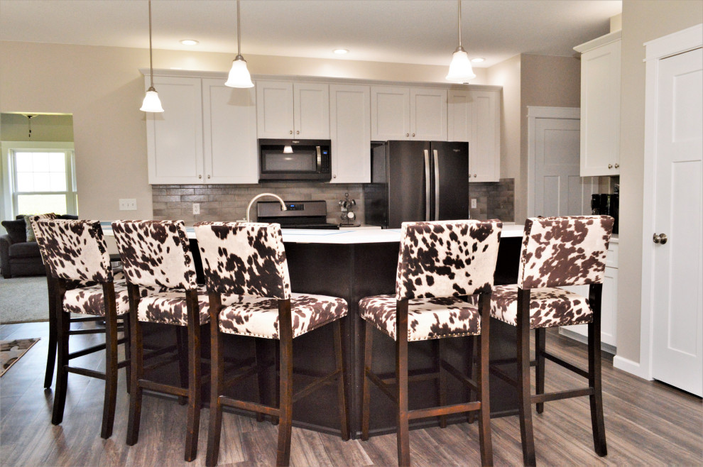 Inspiration for a mid-sized transitional single-wall open concept kitchen remodel with a drop-in sink, shaker cabinets, white cabinets, quartzite countertops, beige backsplash, stainless steel appliances, an island and white countertops