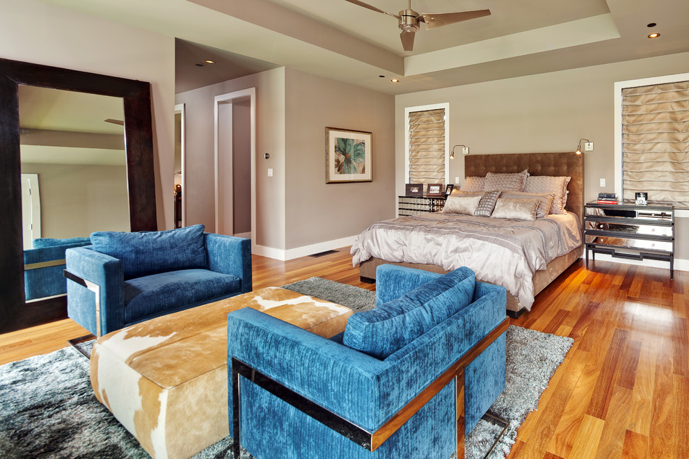 Photo of a large transitional master bedroom in Austin with grey walls and medium hardwood floors.