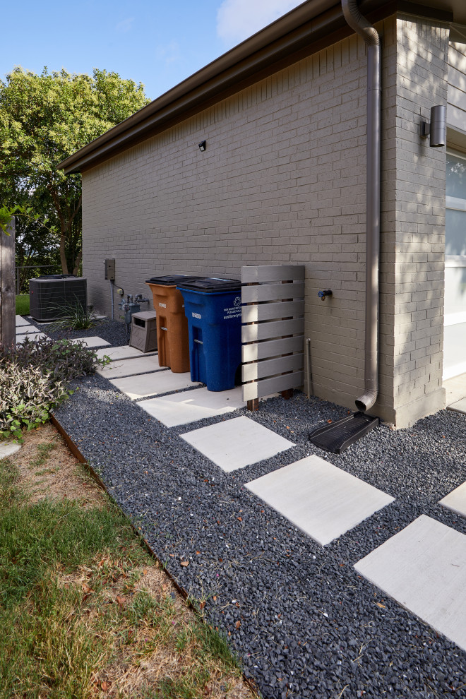Modelo de acceso privado contemporáneo grande en verano en patio delantero con muro de contención, exposición parcial al sol, adoquines de hormigón y con metal