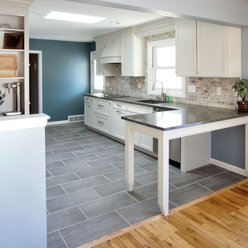 Design ideas for a mid-sized transitional galley eat-in kitchen in Denver with an undermount sink, shaker cabinets, white cabinets, quartz benchtops, beige splashback, stainless steel appliances, a peninsula and grey benchtop.