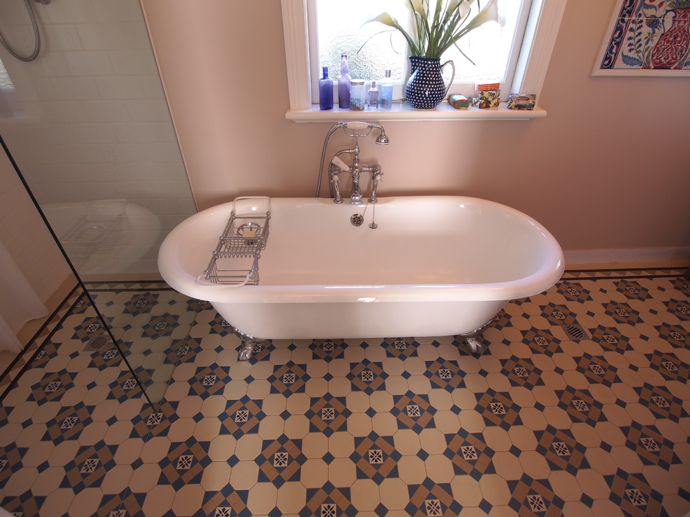 Photo of a mid-sized mediterranean master bathroom in Sydney with an integrated sink, furniture-like cabinets, white cabinets, granite benchtops, a claw-foot tub, a shower/bathtub combo, a two-piece toilet, blue tile, mosaic tile, beige walls and mosaic tile floors.