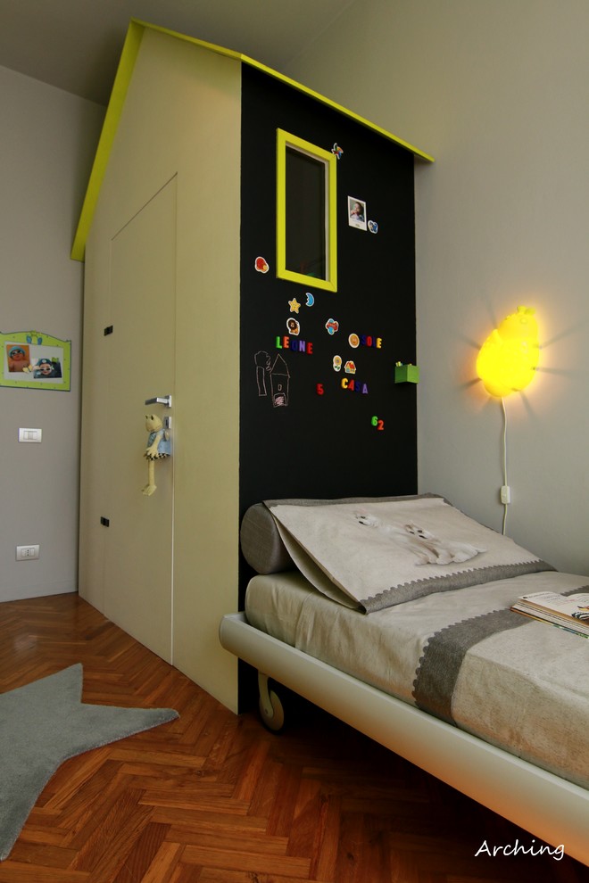 Design ideas for a small contemporary gender-neutral kids' bedroom for kids 4-10 years old in Milan with grey walls and light hardwood floors.