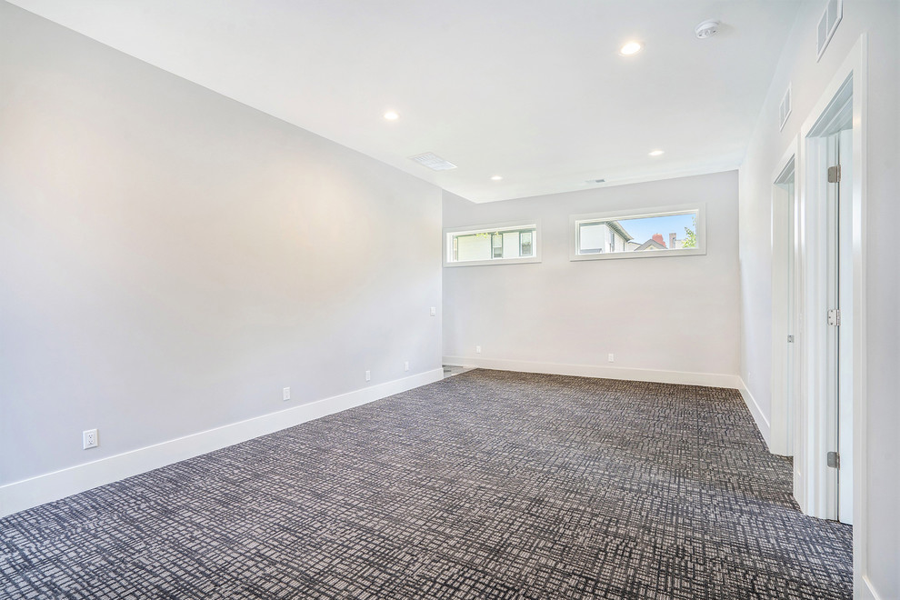 Example of a mid-sized transitional walk-out carpeted and multicolored floor basement design in Grand Rapids