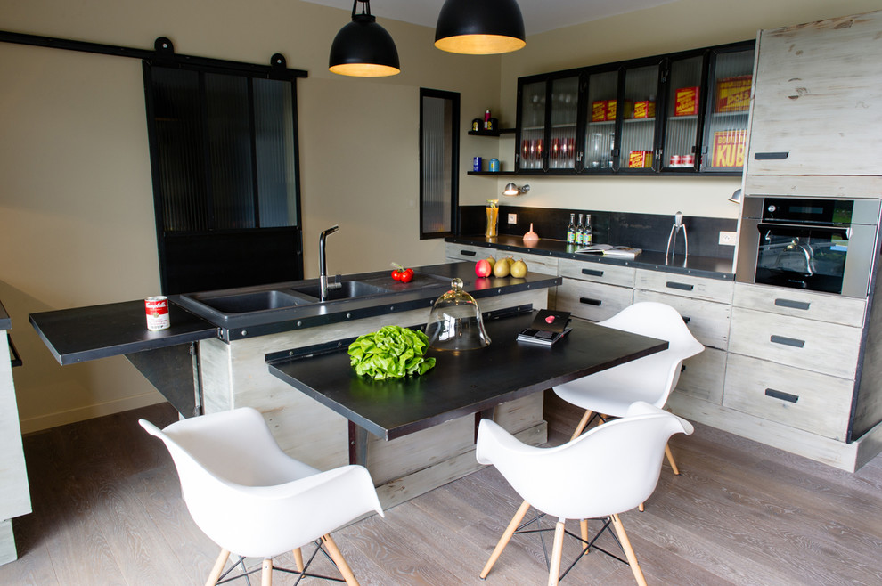 Photo of a mid-sized industrial l-shaped eat-in kitchen in Rennes with a double-bowl sink, light wood cabinets and with island.
