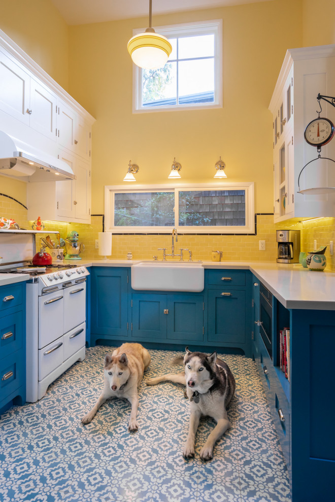 Inspiration for a small country u-shaped eat-in kitchen in Los Angeles with a farmhouse sink, beaded inset cabinets, blue cabinets, quartz benchtops, yellow splashback, subway tile splashback, white appliances, cement tiles, blue floor and white benchtop.