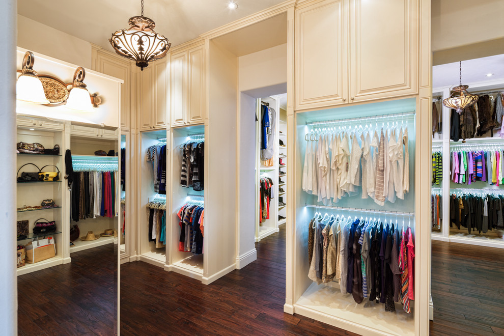 Photo of an expansive contemporary gender-neutral walk-in wardrobe in Tampa with raised-panel cabinets, white cabinets and vinyl floors.